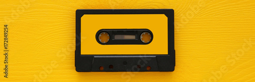 Retro cassette tape over yellow wooden table. top view. copy space