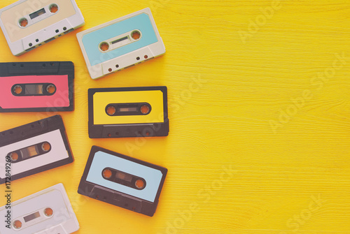 Retro cassette tape collection over yellow wooden table. top view. copy space