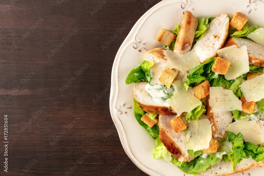 Chicken Caesar salad on dark rustic background with copyspace Chicken Caesar salad on dark rustic background with copyspace