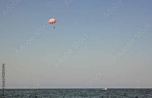 people on a parachute flying over the sea