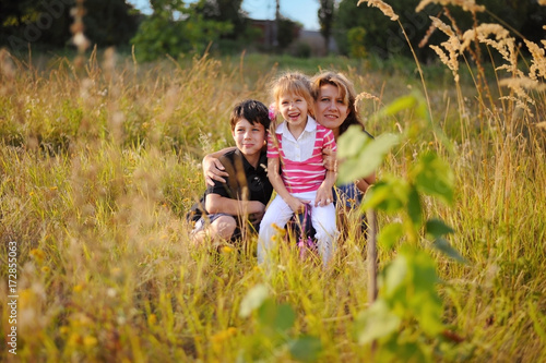 A woman and her children are sitting in high grass