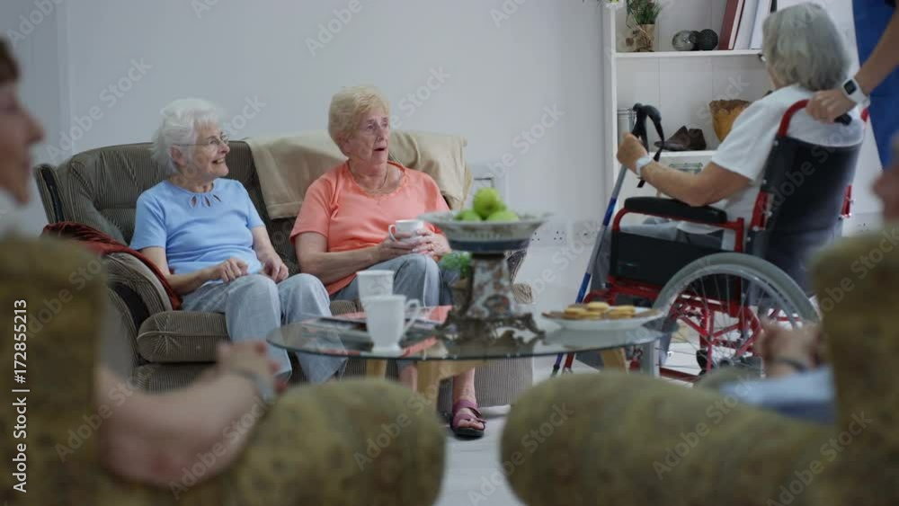 Caring nurse taking care of and talking to elderly residents in a retirement home. Caring nurse taking care of and talking to elderly residents in a retirement home.
