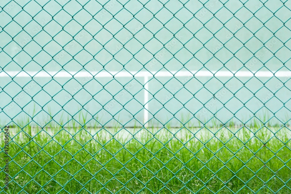 green metal cage front the green tennis court and wall for practice green metal cage front the green tennis court and wall for practice