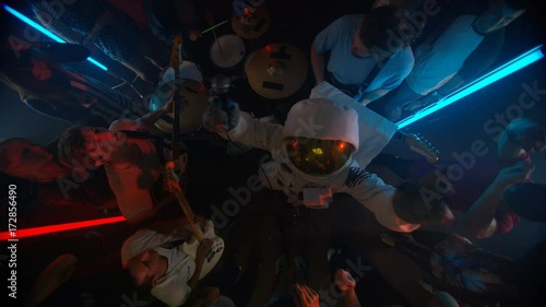  High angle view funny astronaut performing with live band for nightclub crowd photo