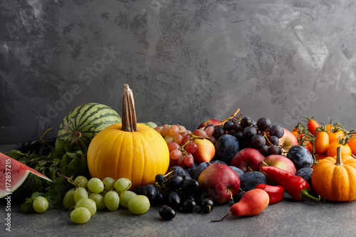 Autumn harvest concept. Seasonal fruits and vegetables on a stone tabletop, top view