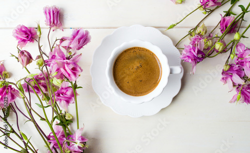 Cup of coffee on a table decorated with flowers