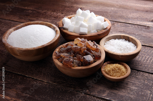 Various types of sugar, brown sugar and white on wooden table