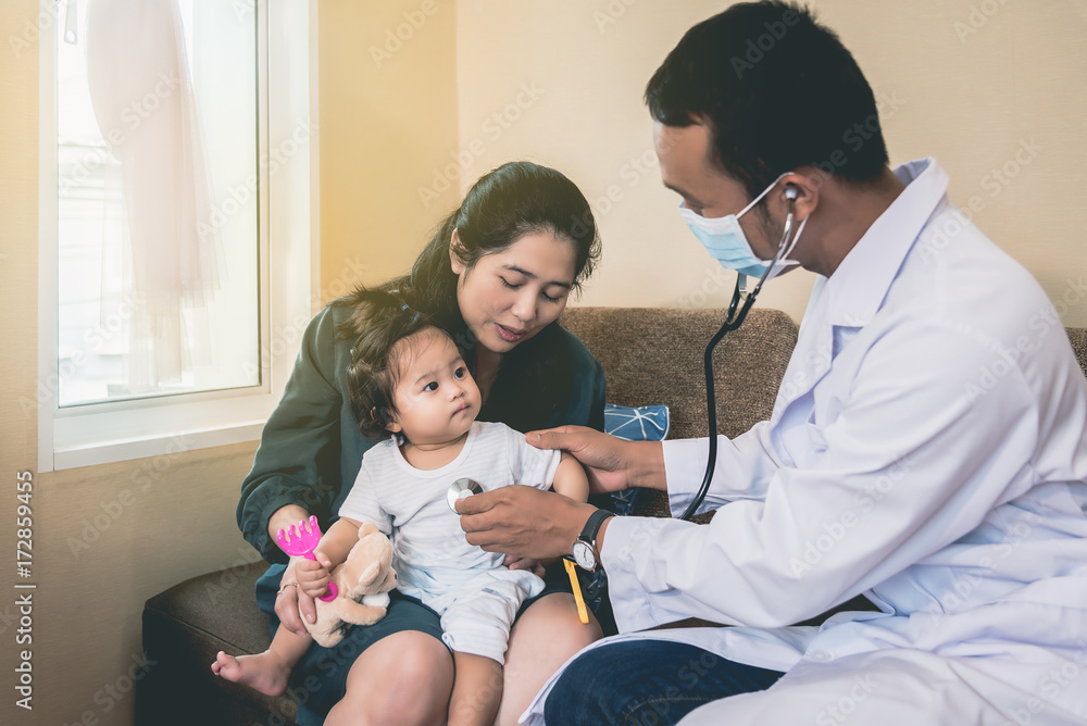 An Asian doctor is checking the symptoms of a sick girl and having her mother with her. An Asian doctor is checking the symptoms of a sick girl and having her mother with her.