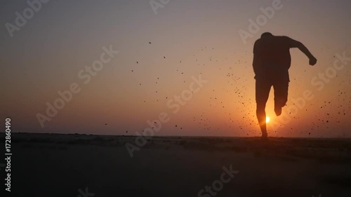 A man runs barefoot on the beach at sunset. HD, 1920x1080. slow motion.