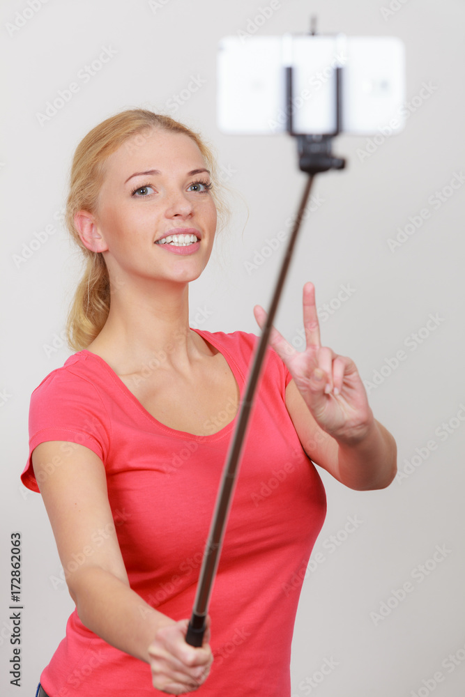 Woman taking picture of herself, phone on stick Woman taking picture of herself, phone on stick