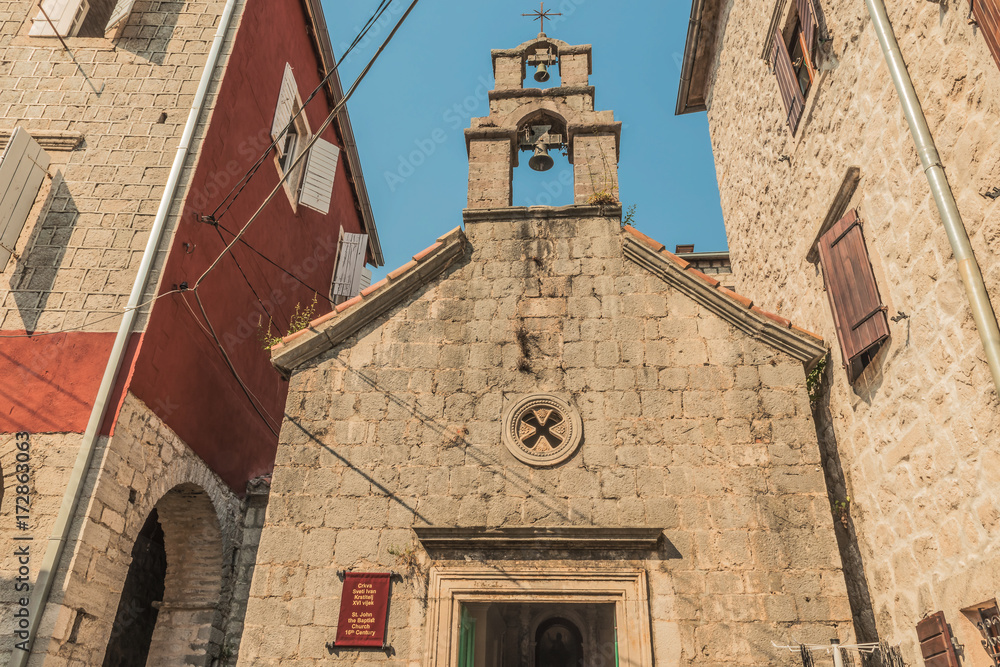 Fototapeta premium View of old church in mediterranean city in croatia Perast in kotor bay, italian venetian architecture style and white bricks.
