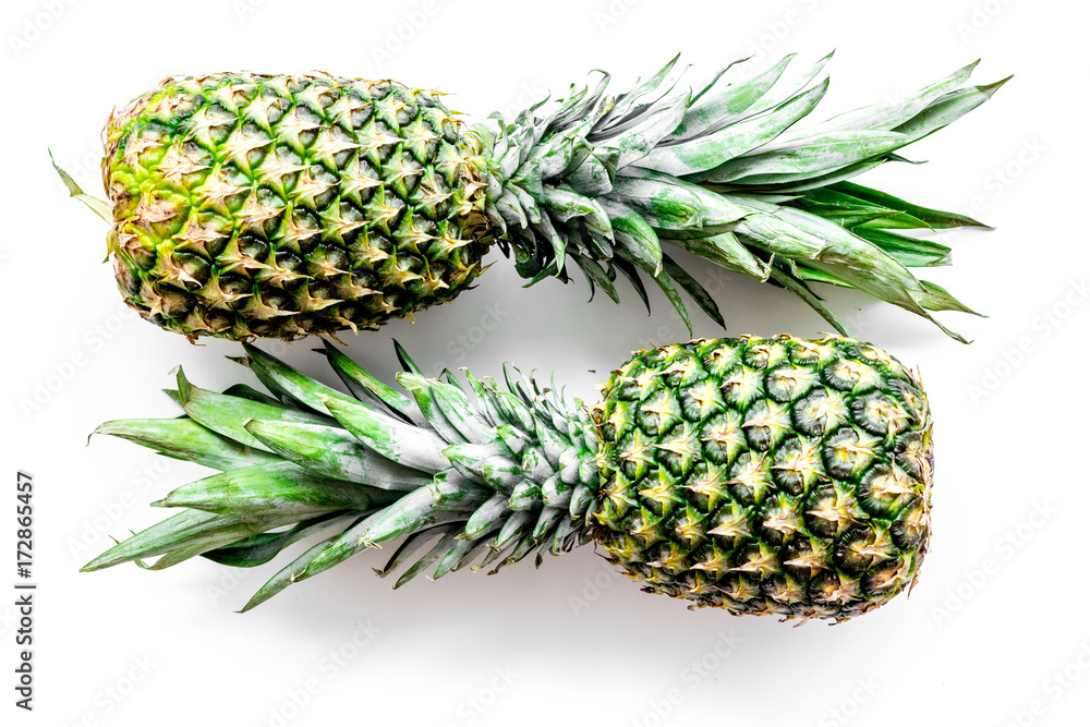 Tropical fruits background. Pinneapple on white top view Tropical fruits background. Pinneapple on white top view