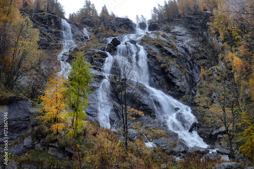 yellow larch and waterfalls in the autumnal Alps © nikitos77