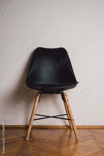 Black plastic chair against the white wall photo