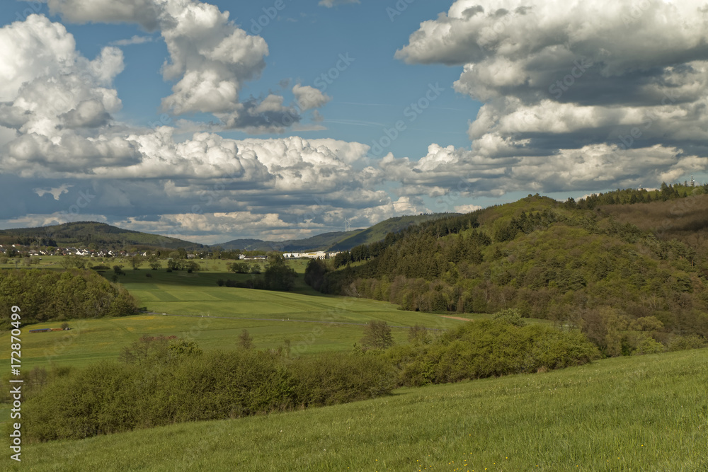 Picturesque hills covered with forests against a background of white clouds