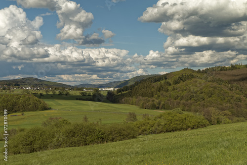 Picturesque hills covered with forests against a background of white clouds © MiroslawKopec
