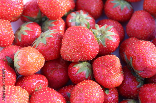 Strawberries background. A set of ordered strawberries. Whole background. Intense red color. Very detailed photo taken with macro lens, full of details