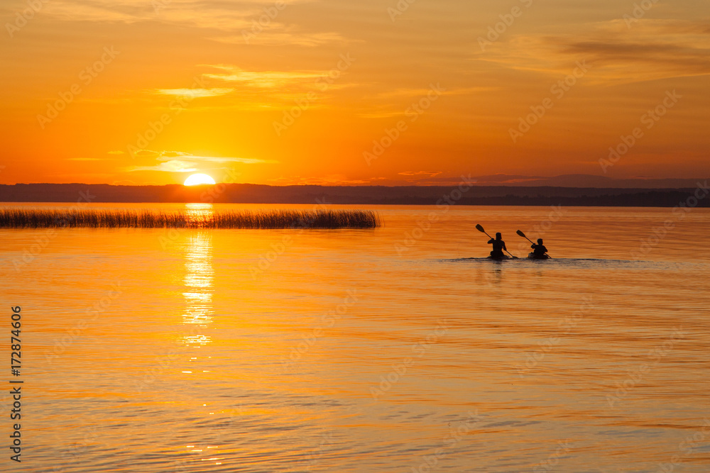 Silhouette of Two Canoeists on Lake during sunset