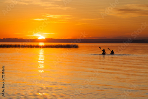 Silhouette of Two Canoeists on Lake during sunset © ronniechua