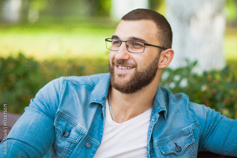 Handsome young man in glasses with beard relax outdoors Handsome young man in glasses with beard relax outdoors