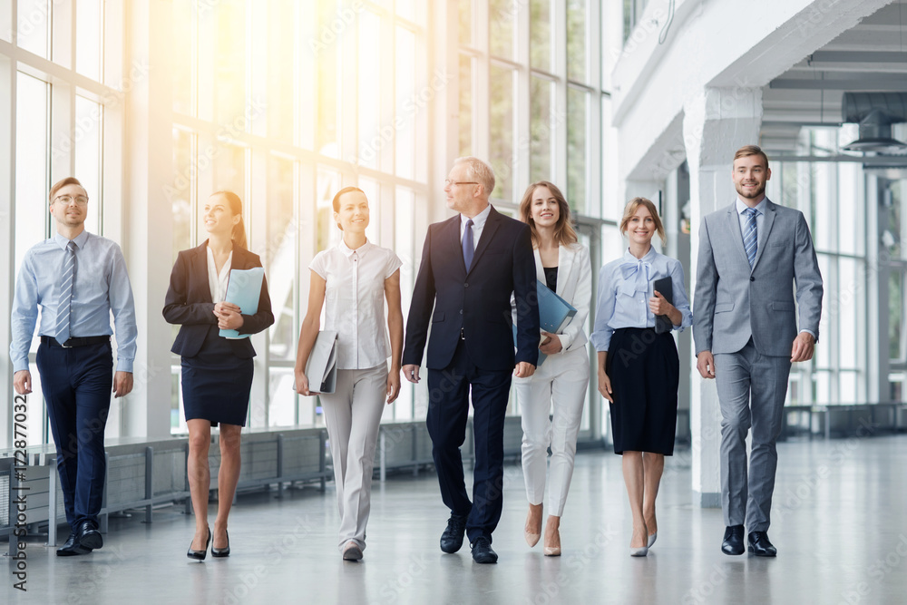 business people walking along office building