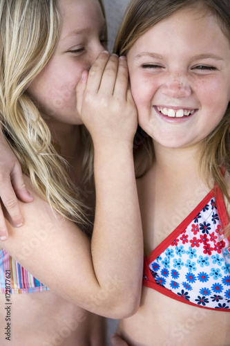Two Girls Wearing Bathing Suits Telling Secrets