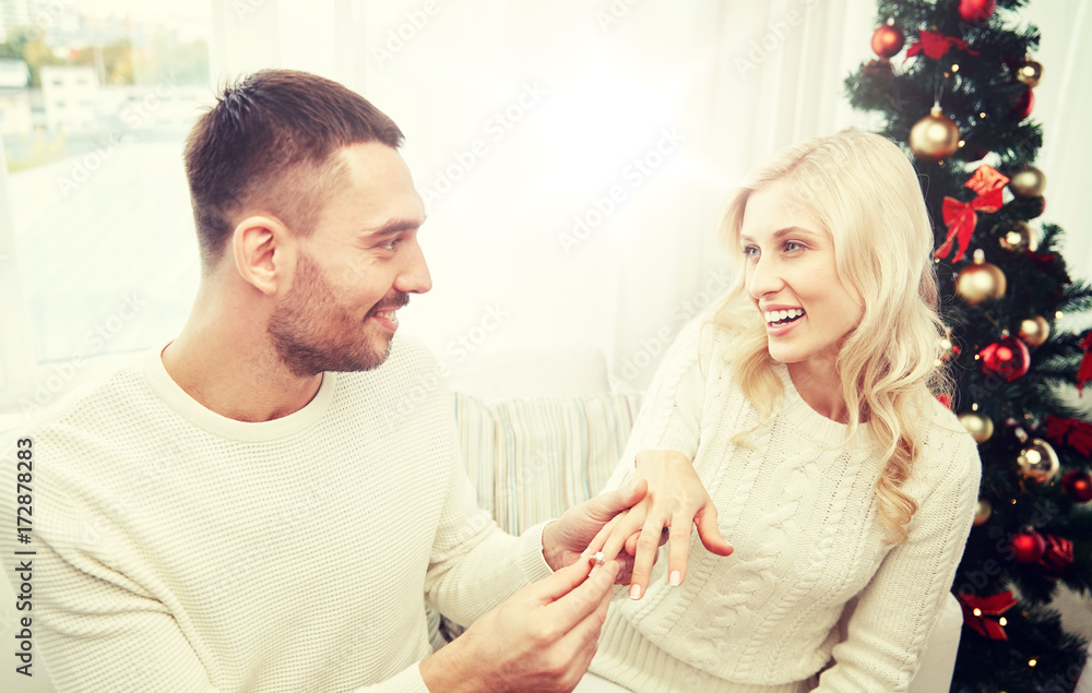 man giving engagement ring to woman for christmas man giving engagement ring to woman for christmas