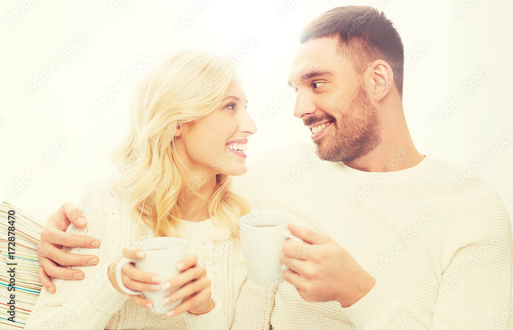 happy couple with cups drinking tea at home happy couple with cups drinking tea at home