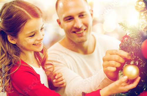 father and daughter decorating christmas tree