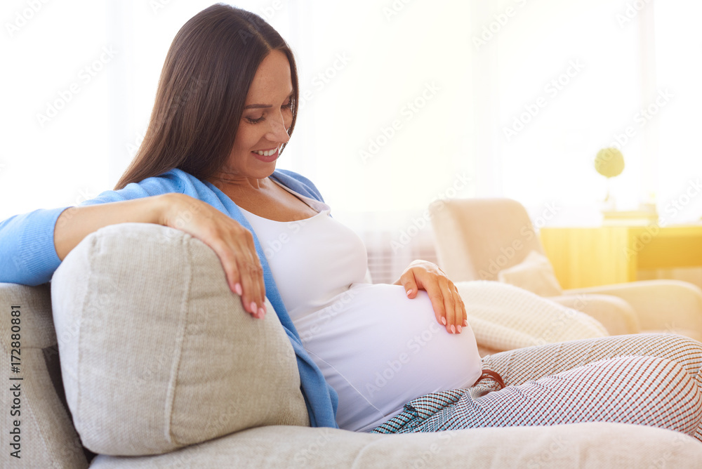 Affectionate loving mother looking at tummy Affectionate loving mother looking at tummy