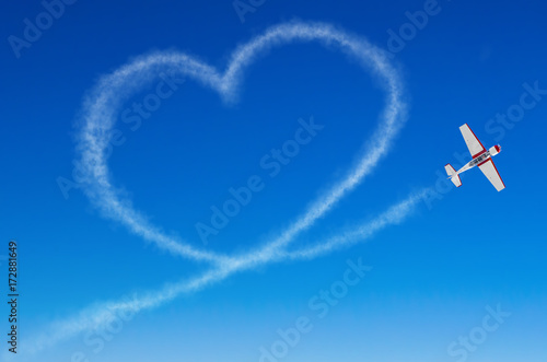 Love figurative heart from a white smoke trail airplane