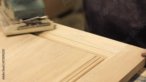 Carpenter is polishing wood surface