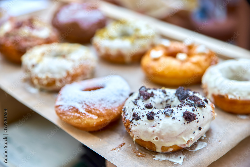 Close-up of tasty baked donuts with glazing and berries in sunlight.Bokeh