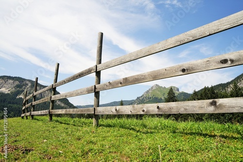 Wooden fence in the Alps under blue sky photo