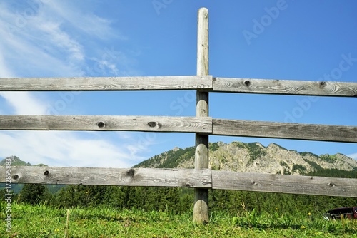 Wooden fence in the Alps under blue sky photo