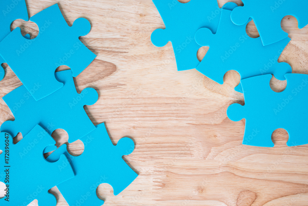 blue jigsaw puzzle pieces on wooden background blue jigsaw puzzle pieces on wooden background