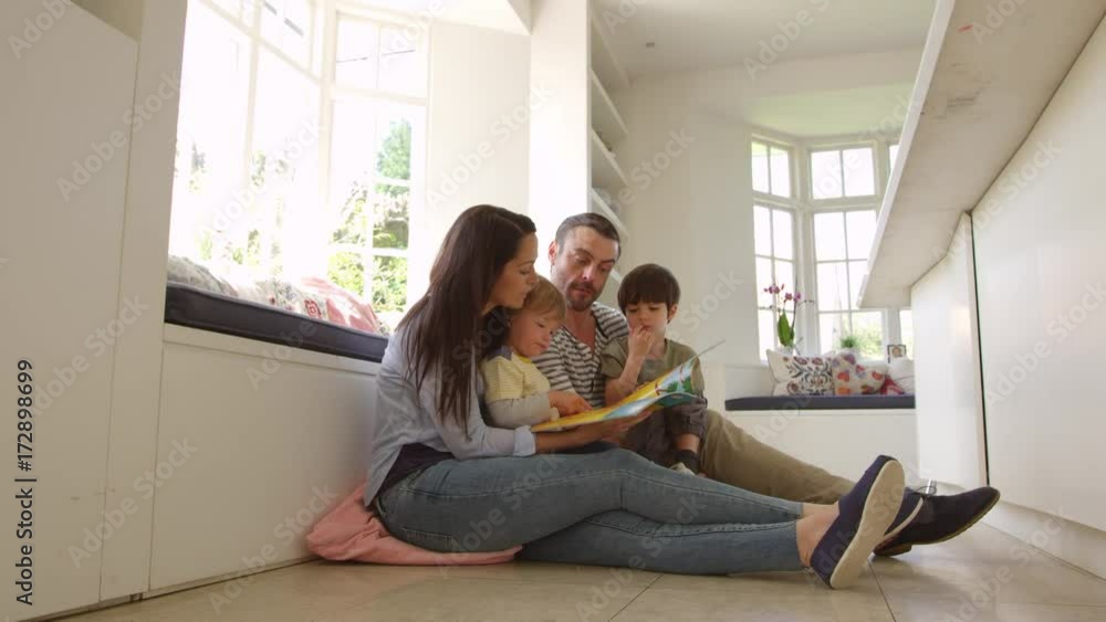 Family Sitting On Floor Reading Story At Home Shot On R3D Family Sitting On Floor Reading Story At Home Shot On R3D