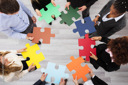 Business People Holding Colorful Jigsaw Puzzles