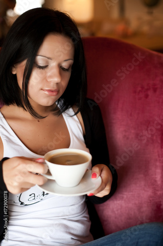 young woman sitting in a cafe drinking coffee