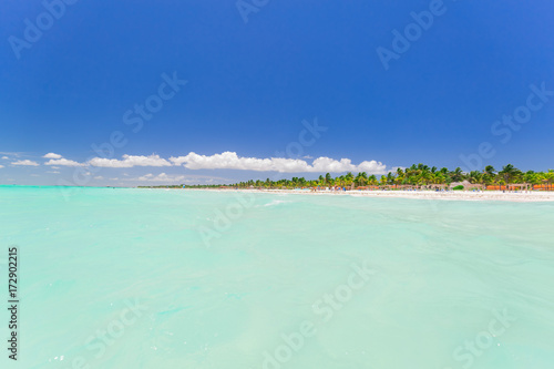 beautiful gorgeous, inviting tranquil, turquoise soft ocean and tropical palm beach at Cuban Cayo Coco island on sunny summer day