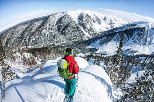 Man standing at top of ridge. Ski touring in mountains. Adventure winter freeride extreme sport photo