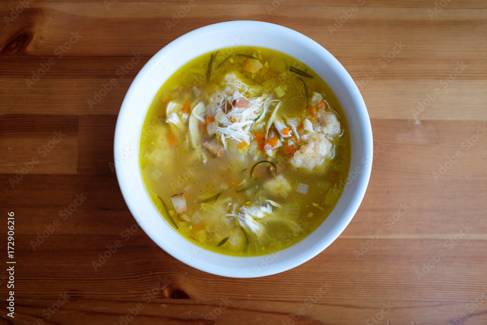 Homemade chicken and dumpling soup on a wooden table. Homemade chicken and dumpling soup on a wooden table.