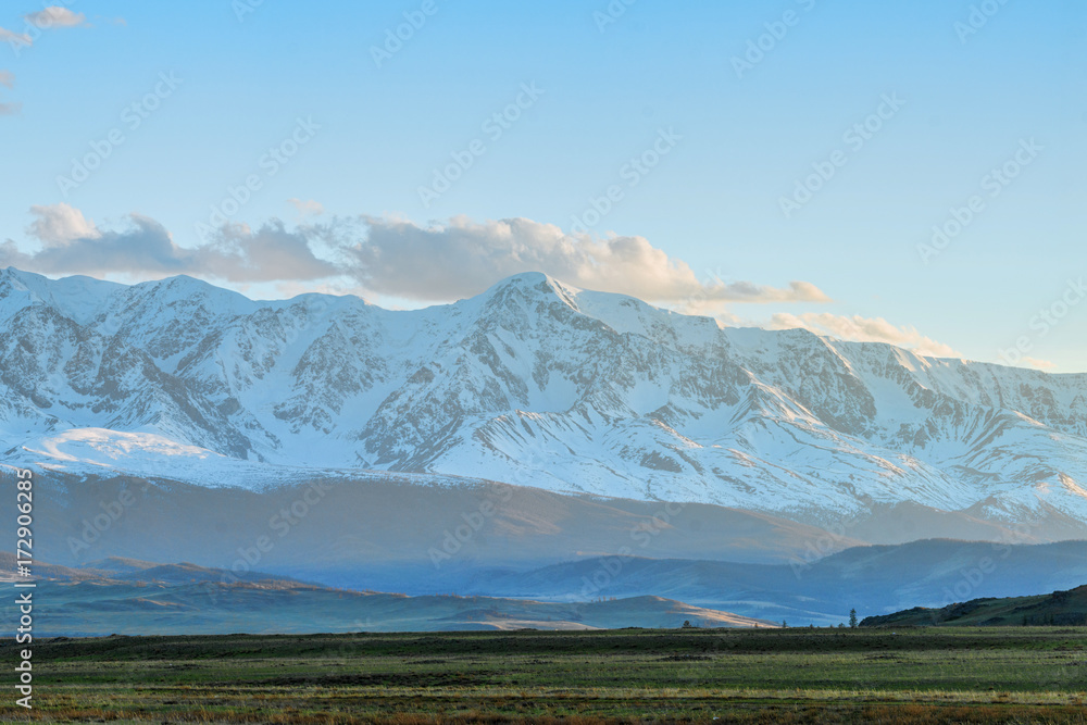 Fototapeta premium panoramic view of plain at root of great mountains with snowy tops 