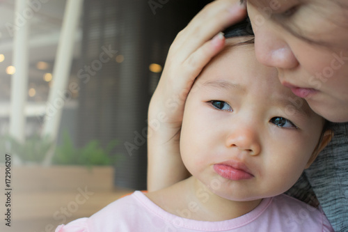 Mother soothing crying little girl.