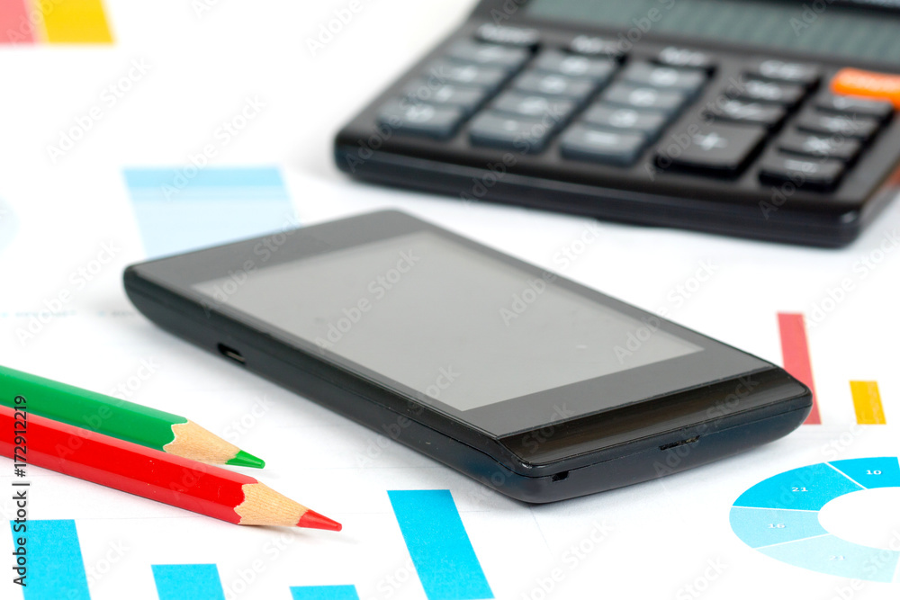 manager working place, mobile phone and calculator over colorful business charts manager working place, mobile phone and calculator over colorful business charts