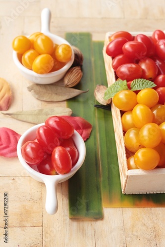 Red and yellow tomatoes organic on wood background