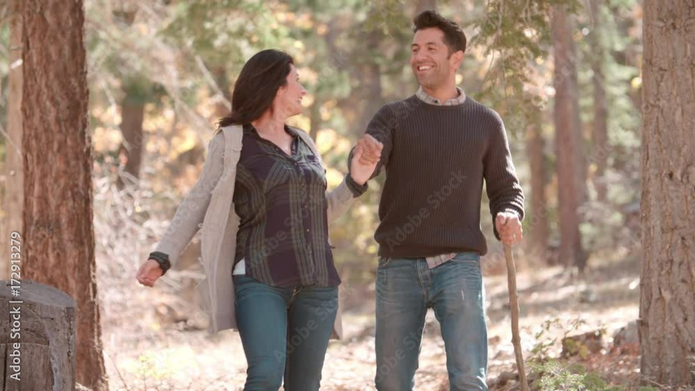 Hispanic couple walk in forest holding hands, close up Hispanic couple walk in forest holding hands, close up