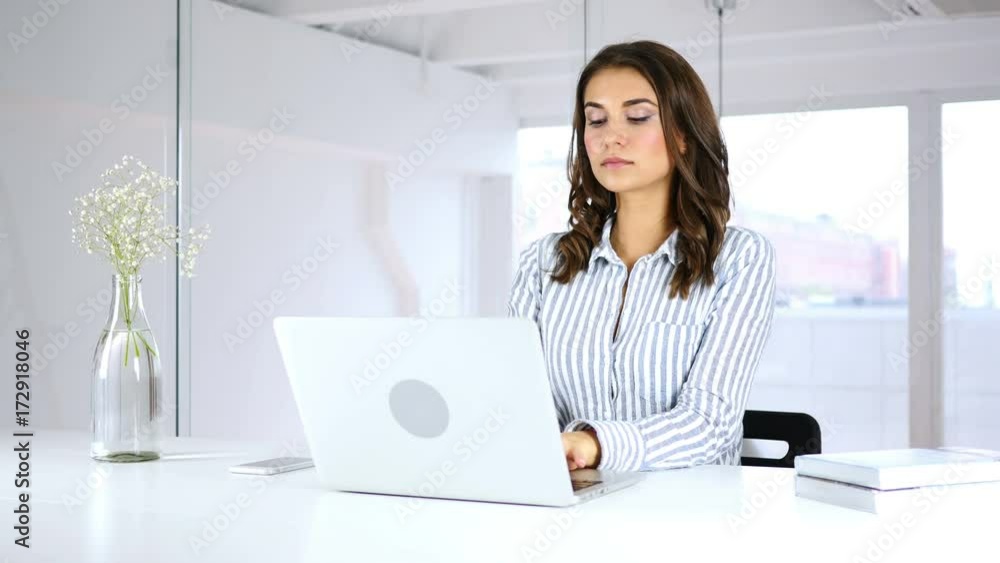 Serious Woman Working On Laptop in Office Serious Woman Working On Laptop in Office