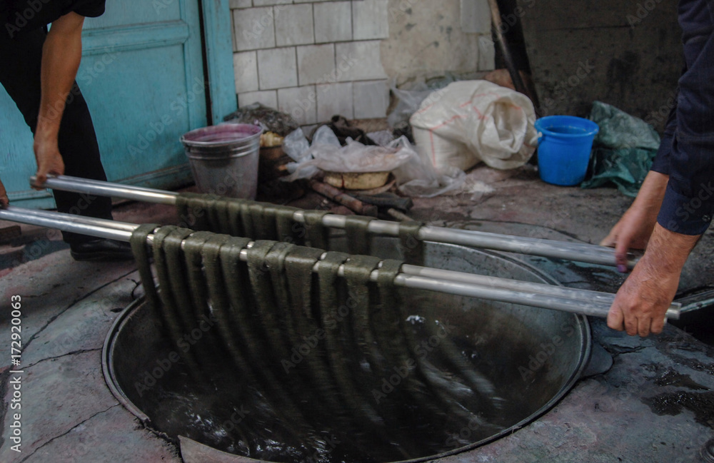 dyeing of finished yarn. two men manually dye yarn