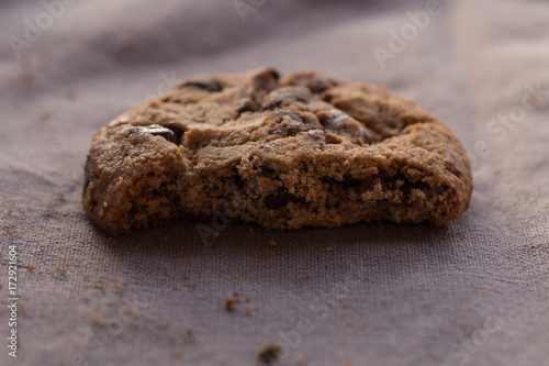 Closeup chocolate chips cookies with bite on brown background